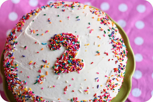 A close up of a birthday cake with the number 2 on it in sprinkles