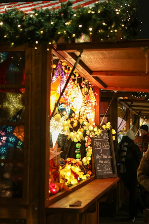 Free Vibrant lights and decorations at a Berlin Christmas market stall, creating a festive atmosphere. Stock Photo