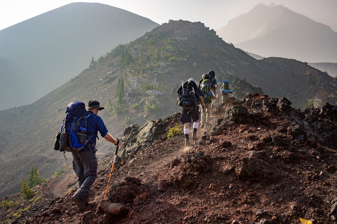 Free Group of hikers trekking on a rugged mountain trail in Oregon's scenic outdoors. Stock Photo