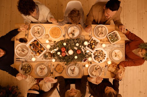 Free Family gathered around a beautifully set table for a festive Christmas dinner celebration. Stock Photo