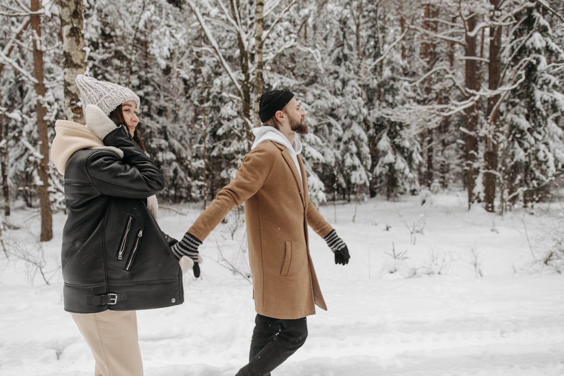 Free A couple enjoying a winter stroll in a snowy forest, exuding warmth and intimacy. Stock Photo