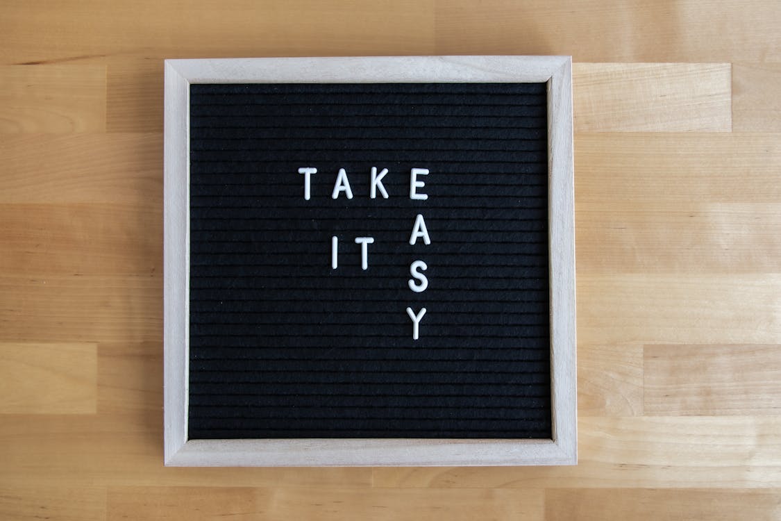 Free Blackboard sign with 'Take It Easy' message, perfect for relaxation themes. Stock Photo