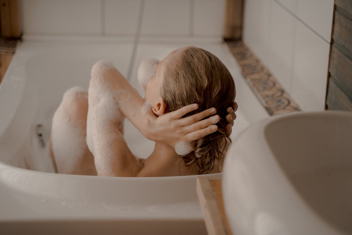 Free A serene moment captured as a woman soaks in a bathtub, embracing bubbles. Stock Photo