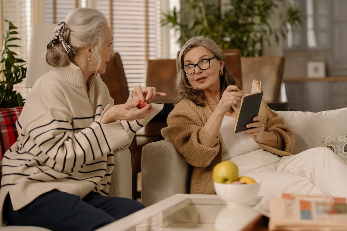 Free Two senior women having a warm and intimate conversation on a cozy couch indoors. Stock Photo