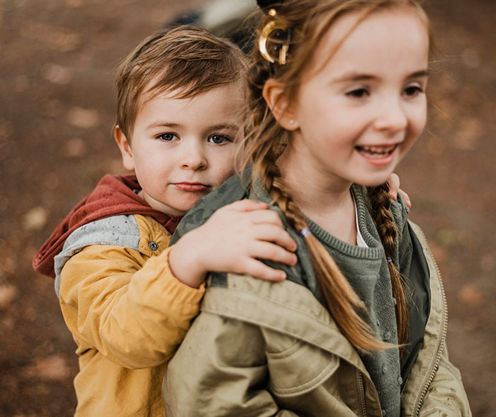Young boy with brother outdoors highlighting family care and sibling relationships involving disabled care responsibilities.