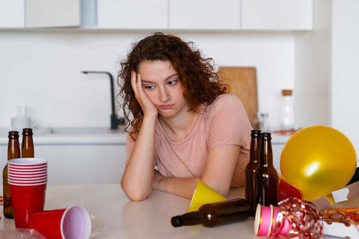 Teen loses patience at messy celebration as golden child cousin turns event into her own show, showing frustration and exhaustion.