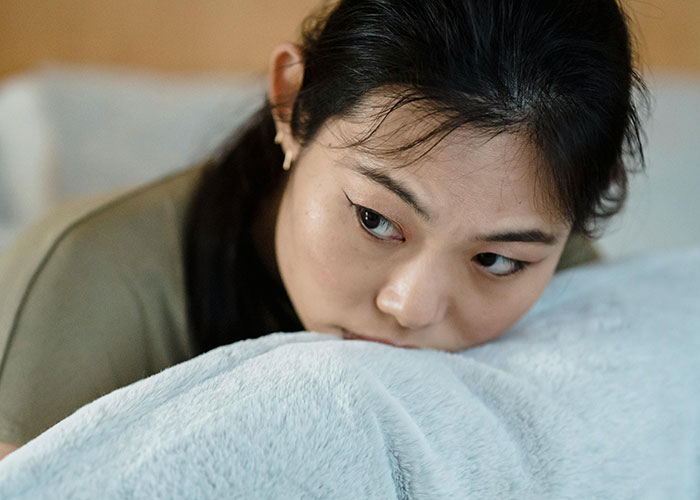 Woman looking upset and deep in thought, reflecting on husband’s betrayal despite his supportive and kind appearance.